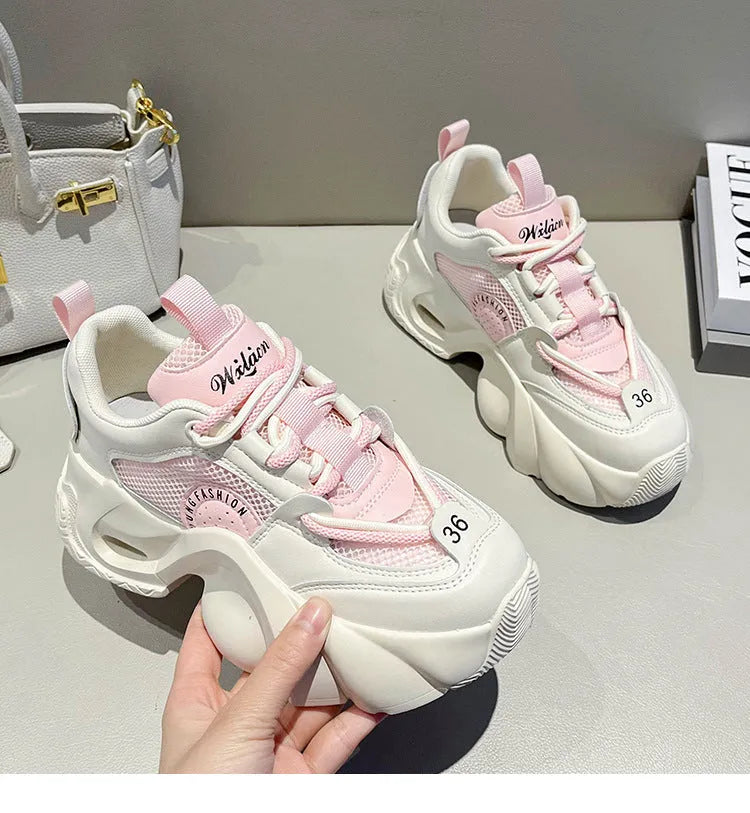 Women's pink sneakers with thick sole, cross ankle straps and mesh lining.