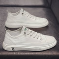 Men's casual white shoes with round toe and flat low-heel sole on a plain background.