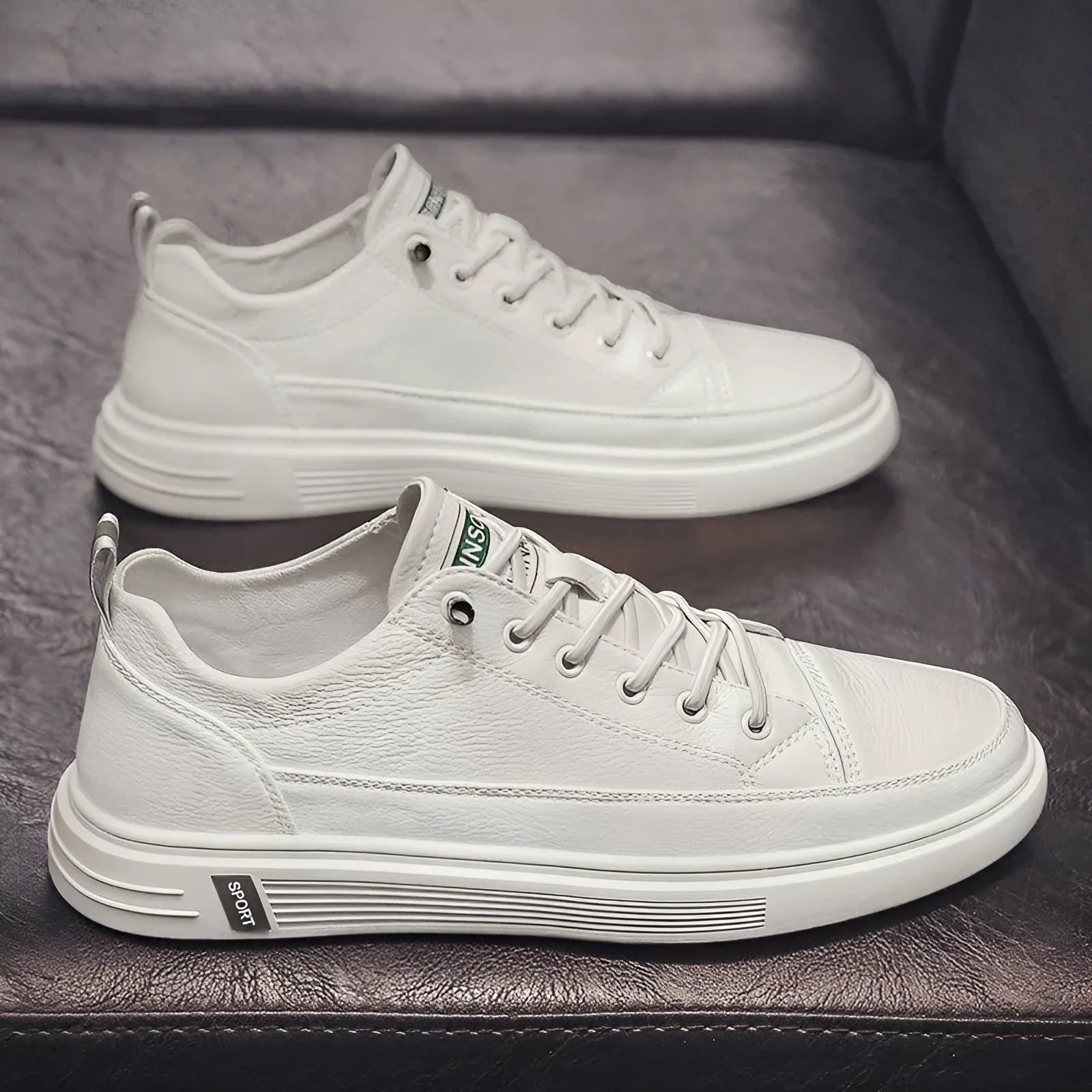 Men's casual white shoes with round toe and flat low-heel sole on a plain background.