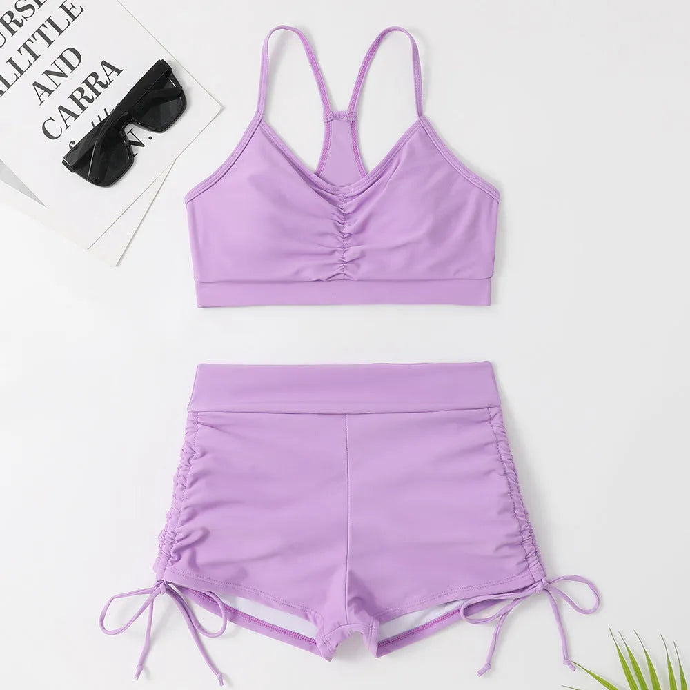 Women's high-waist split bikini swimsuit in black or purple colour with sleeveless design