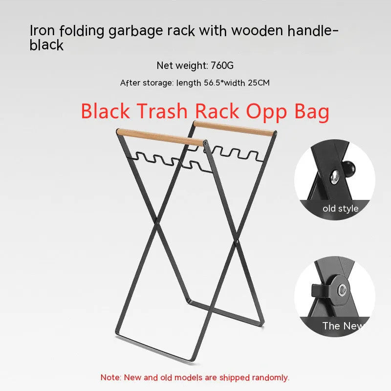 Folding black outdoor trash bag hanger with wooden carry handle on a patio.