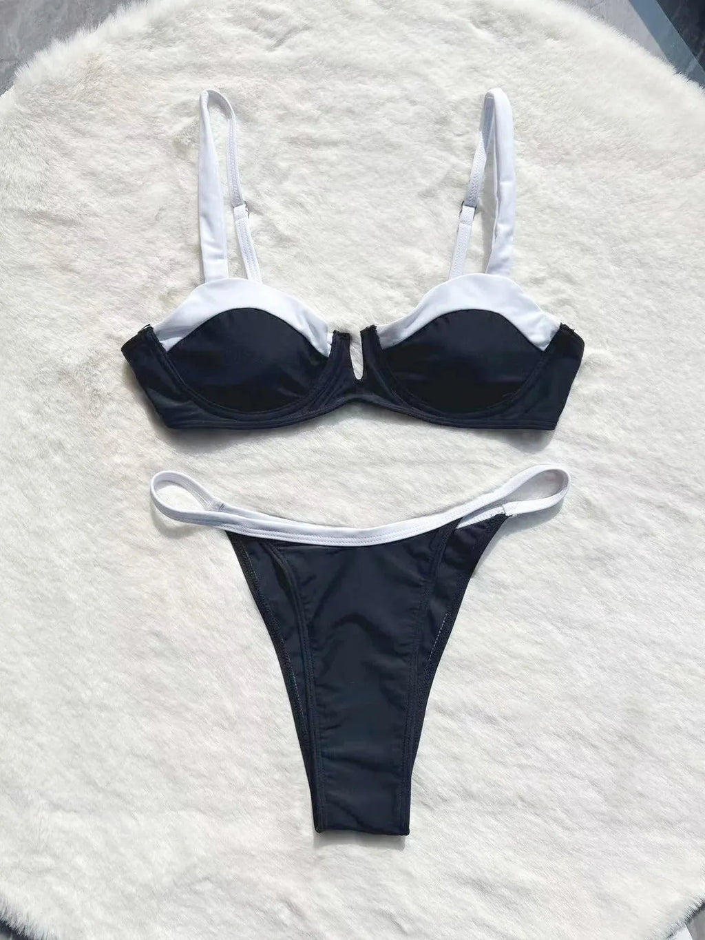 Black low-waist women's bikini swimsuit with stitching detail on a mannequin