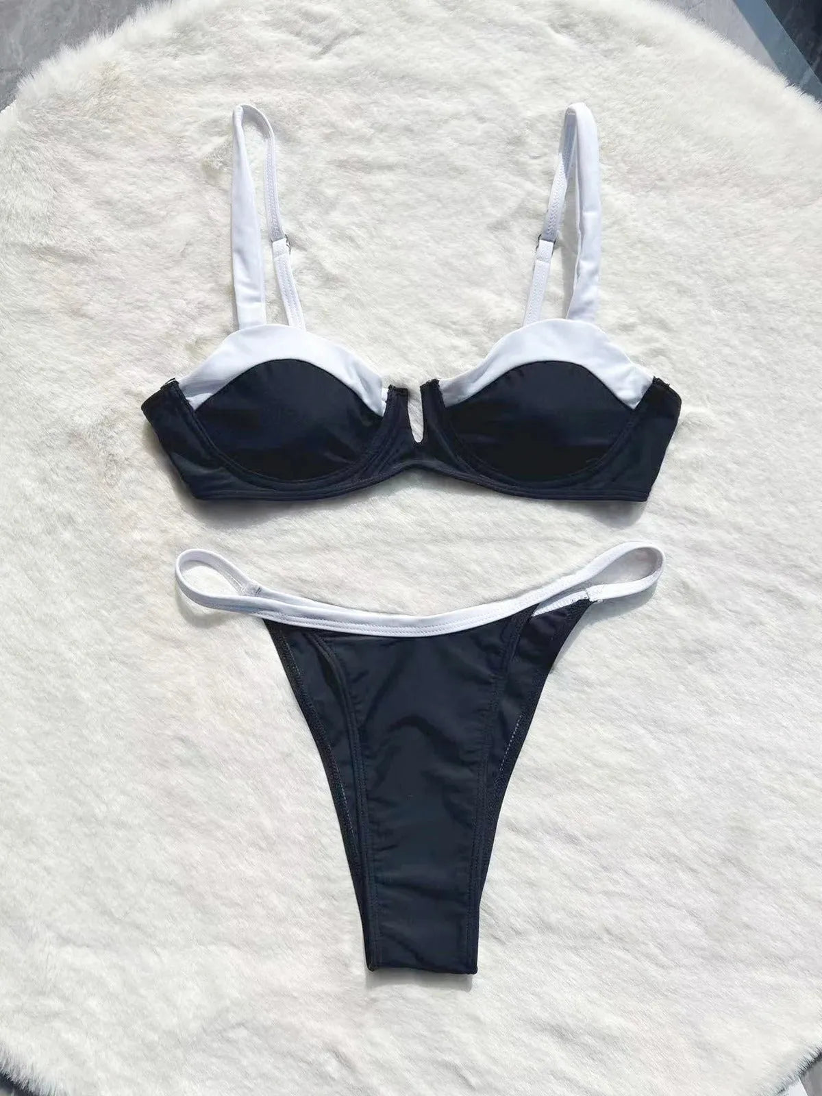 Black low-waist women's bikini swimsuit with stitching detail on a mannequin