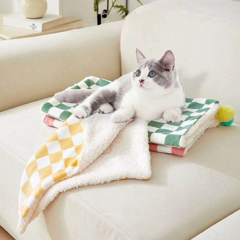 Plush cotton fleece pet blanket with plaid pattern and fur balls in green colour on couch