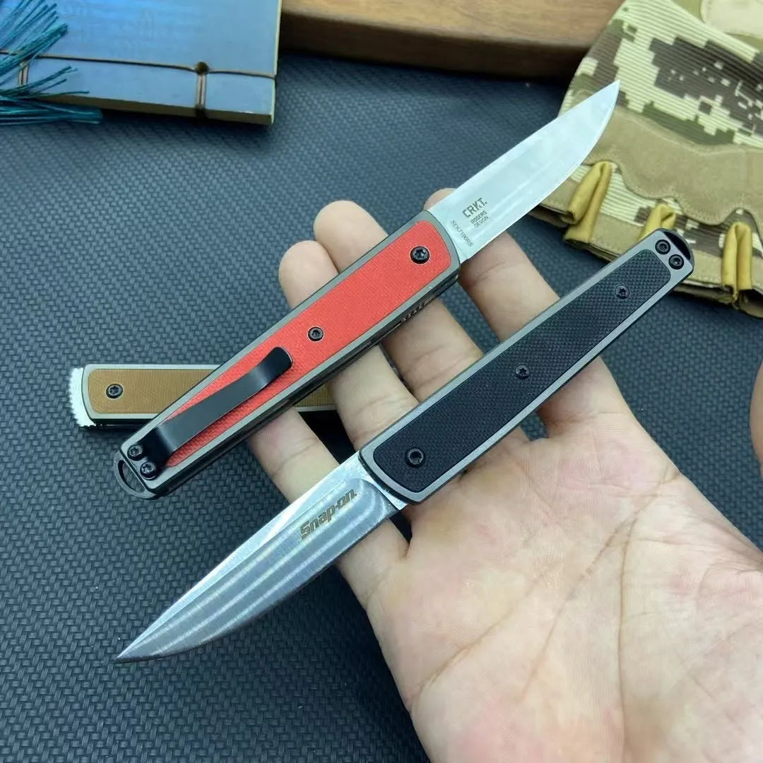 Closed and open views of a folding fruit knife with a coloured handle and stainless steel blade.