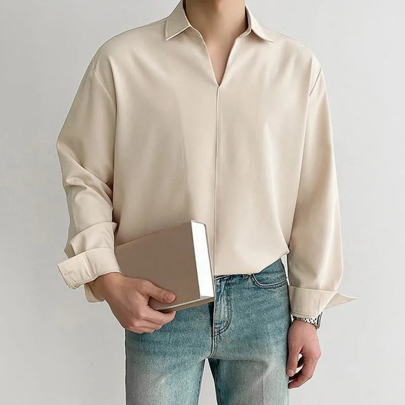 Man wearing a loose fit, solid colour, long sleeve casual shirt suitable for business.