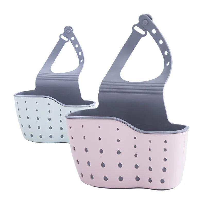 Set of three plastic kitchen sink storage racks in light blue, light pink, and beige on a countertop