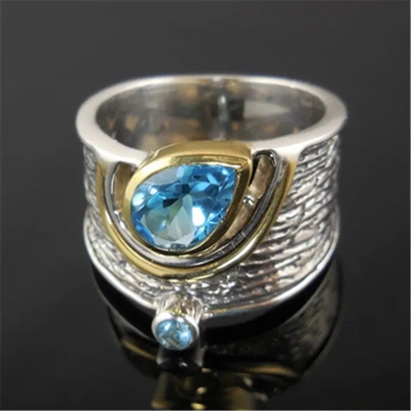 Blue Chinese style alloy ring with inlaid rhinestones in a drop shape on a white background.