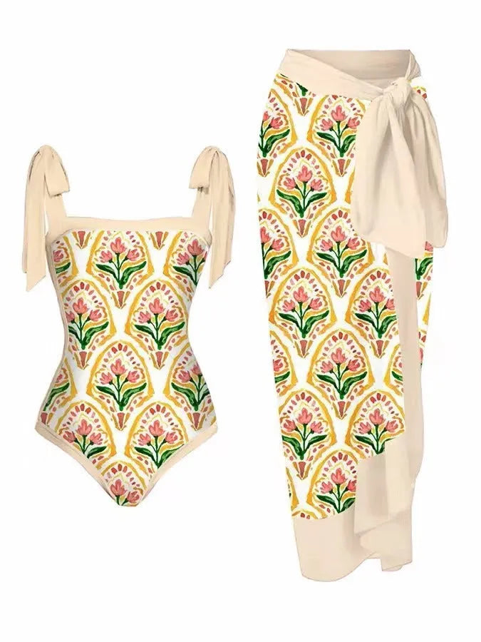 Women's floral print two-piece swimsuit with a blue chiffon skirt laid flat.