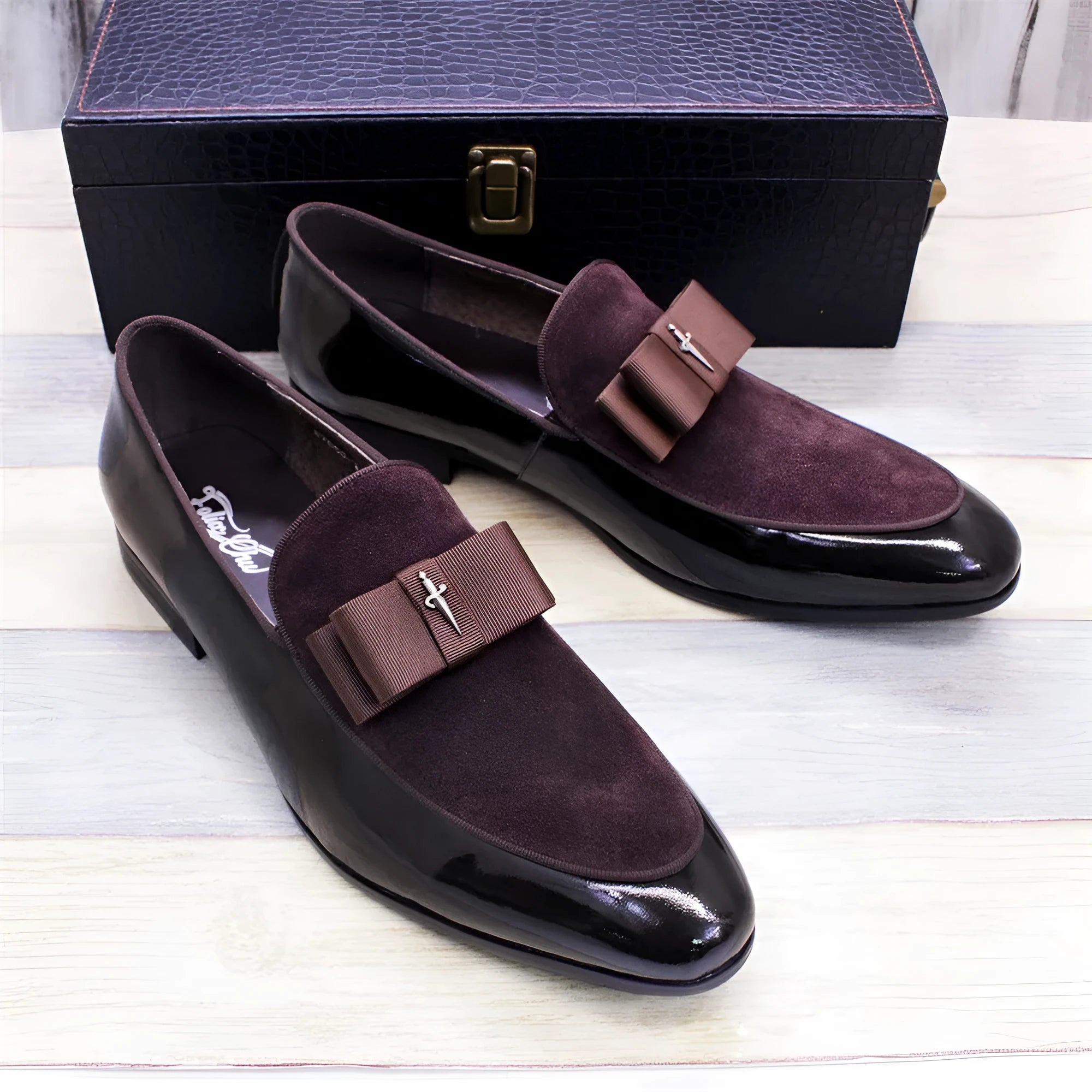 Men's black patent leather low-top dress shoes with a tassel detail on the front.
