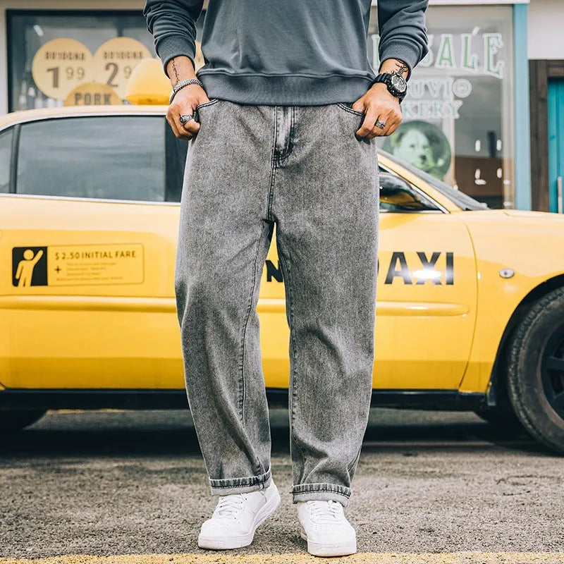 Man wearing dark blue loose straight-cut cotton jeans with a mid-waist and zipper fly.