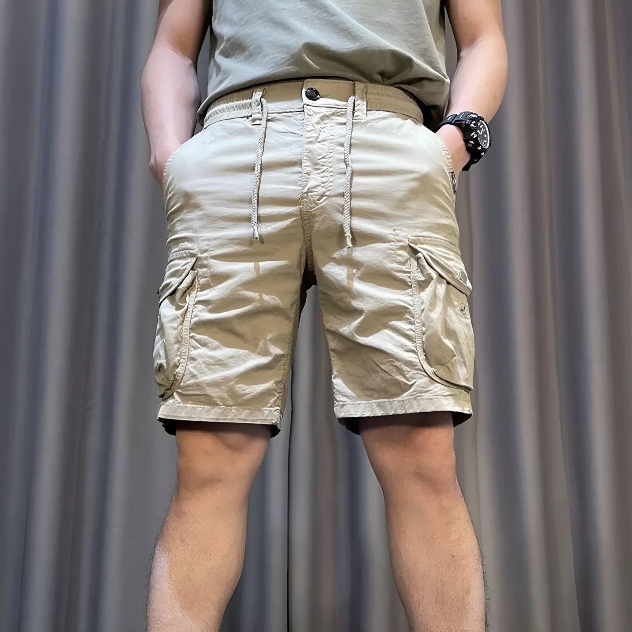 A model wearing loose straight-leg multi-pocket overalls in a khaki colour.