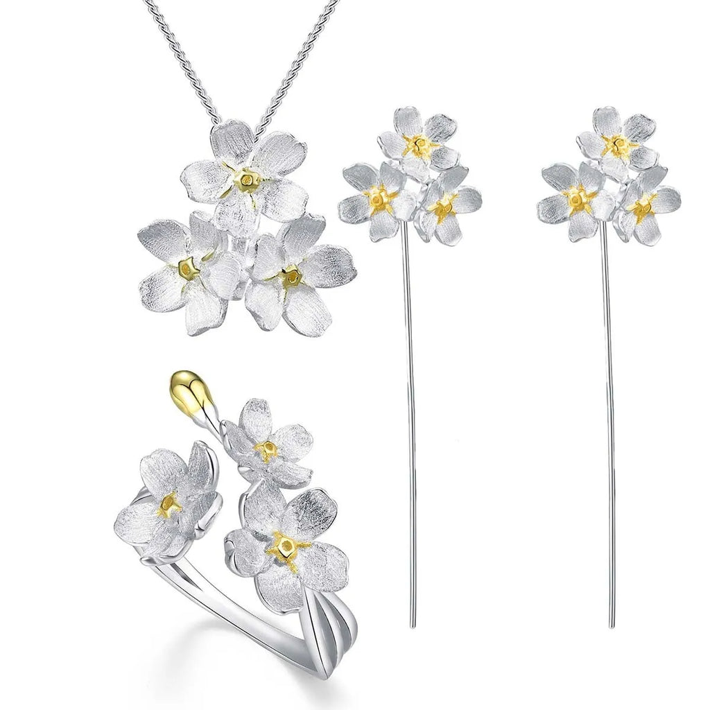 Silver open mouth Myosotis Sylvatica flower pendant with electroplated finish on a dark background.
