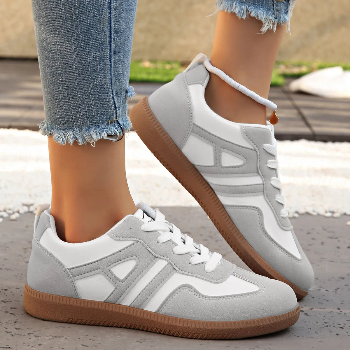 Women's retro grey jogging shoes with lace-up front and cross-strap detail on a rubber platform sole.