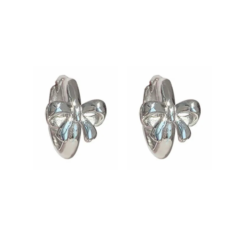 Pair of 925 sterling silver bow earrings with electroplated silver finish on white background