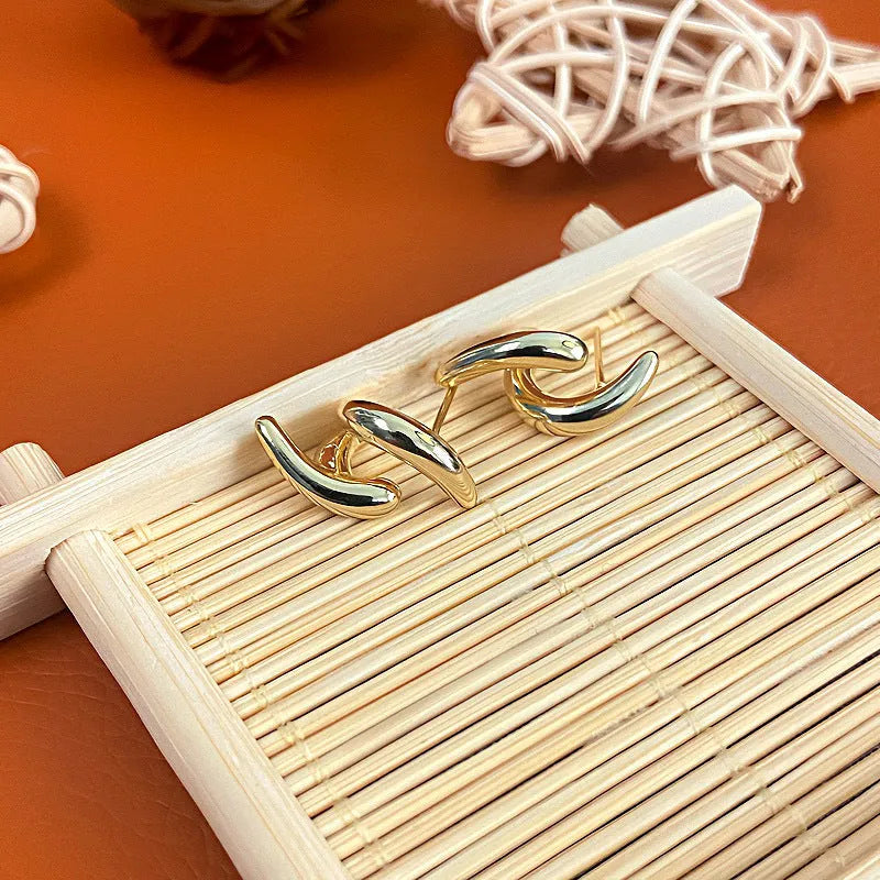 Pair of geometric copper stud earrings with textured line design and electroplated finish