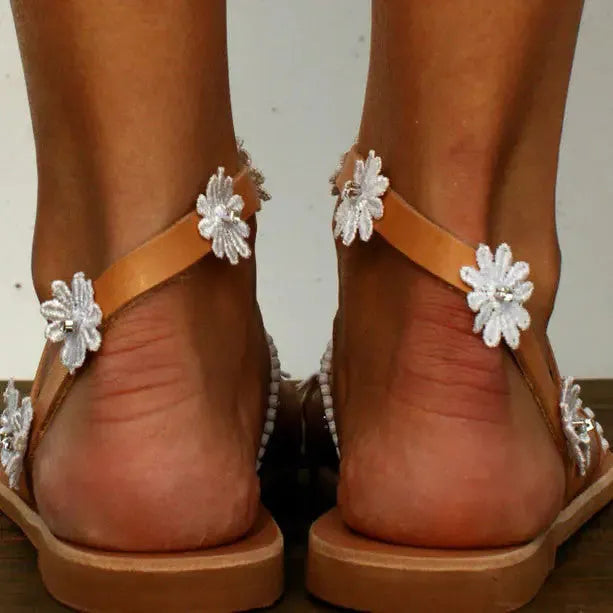 Brown ladies Roman sandals with flower decoration and flat rubber sole