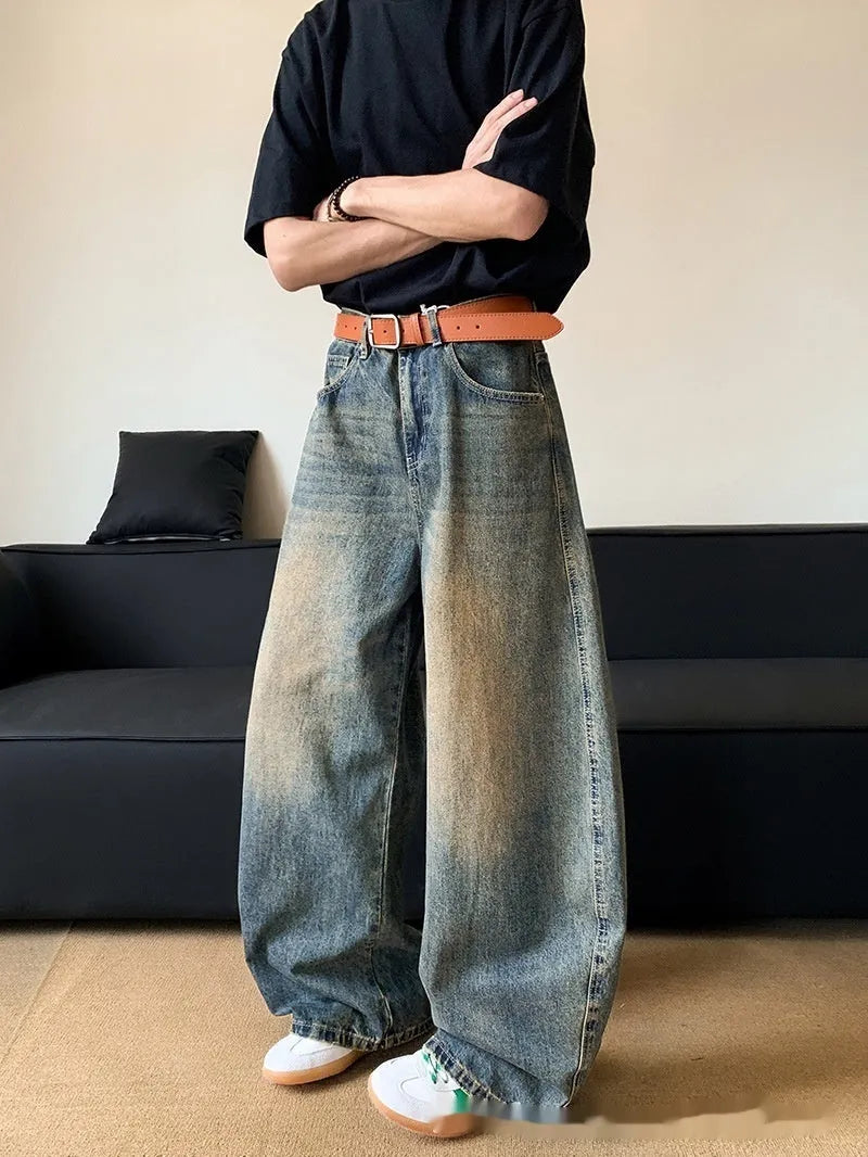 Men's retro blue distressed denim pants with a slim wide-leg fit and a zipper fly.