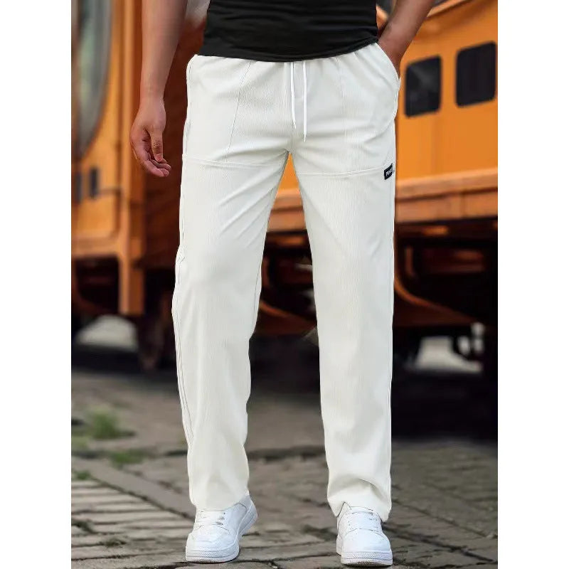 Men's polyester trousers for spring and autumn in light grey, shown flat.
