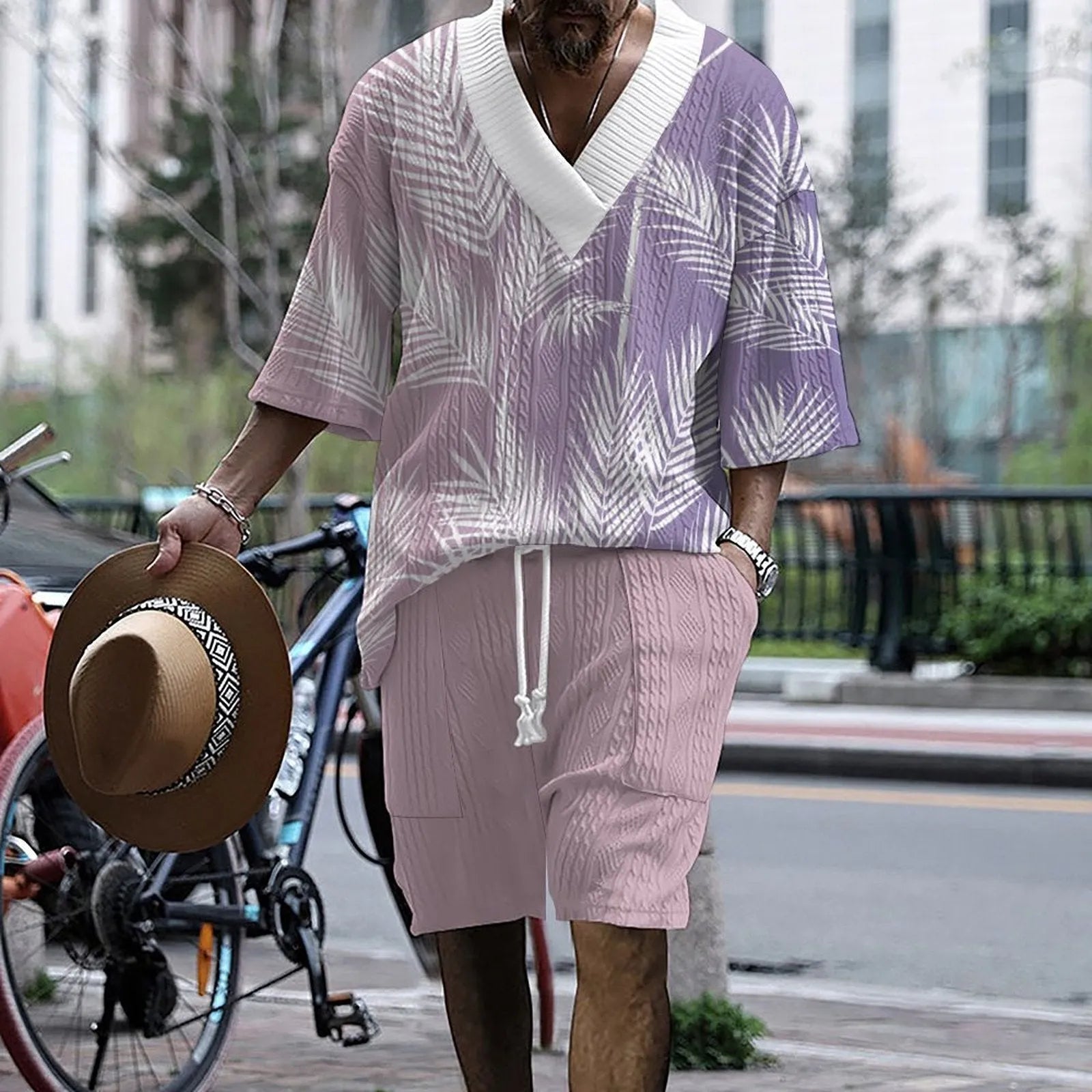 A man wearing a printed drop-shoulder knitted short-sleeved top with matching shorts in a casual setting.