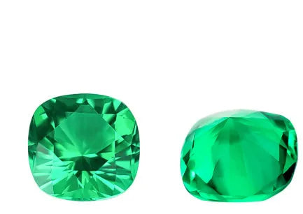 Cultivated emerald gemstone in Columbian green colour showing various polished cuts on a white background.