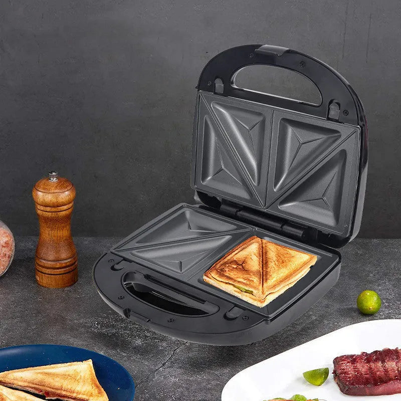 Black electric sandwich pan with double-sided heating, brushed stainless steel top, and non-stick baking surface