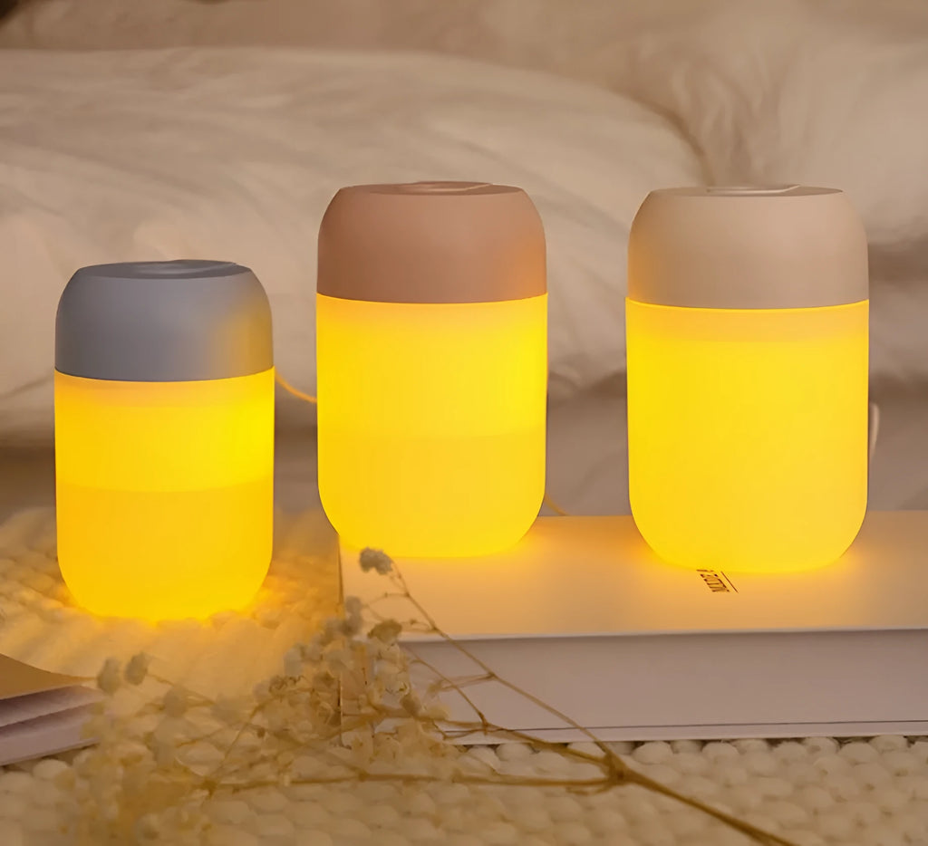 Small white cylindrical USB-powered mini humidifier on a wooden desk.