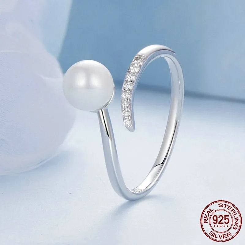 Adjustable sterling silver ring with natural shell pearls and open loop design