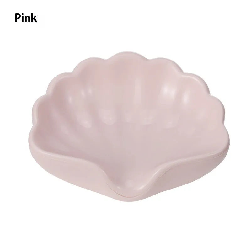 White shell-shaped plastic soap dish on a bathroom counter.