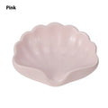 White shell-shaped plastic soap dish on a bathroom counter.