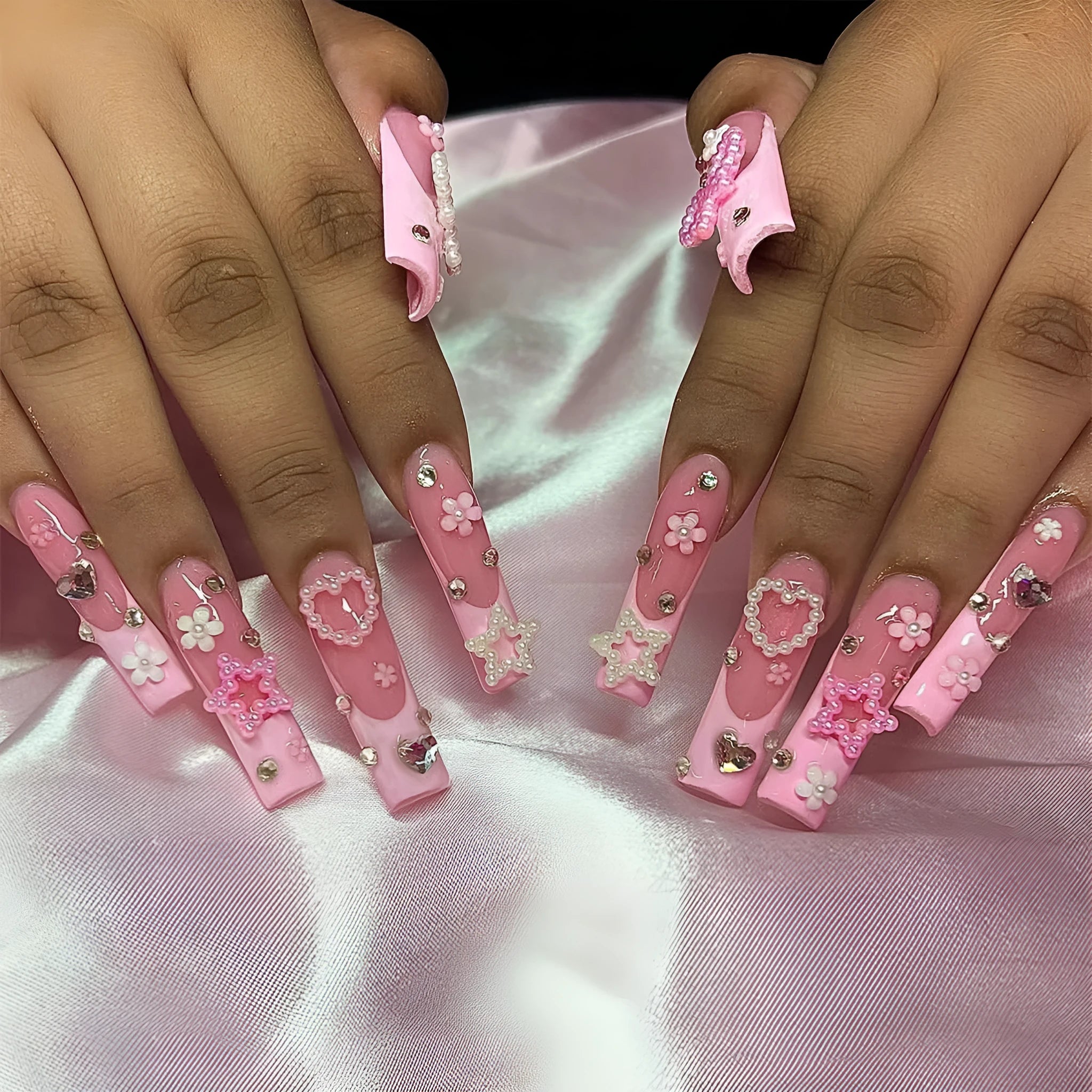 Super long water pipe shaped false nails with a French spot design and decorative bow accent.