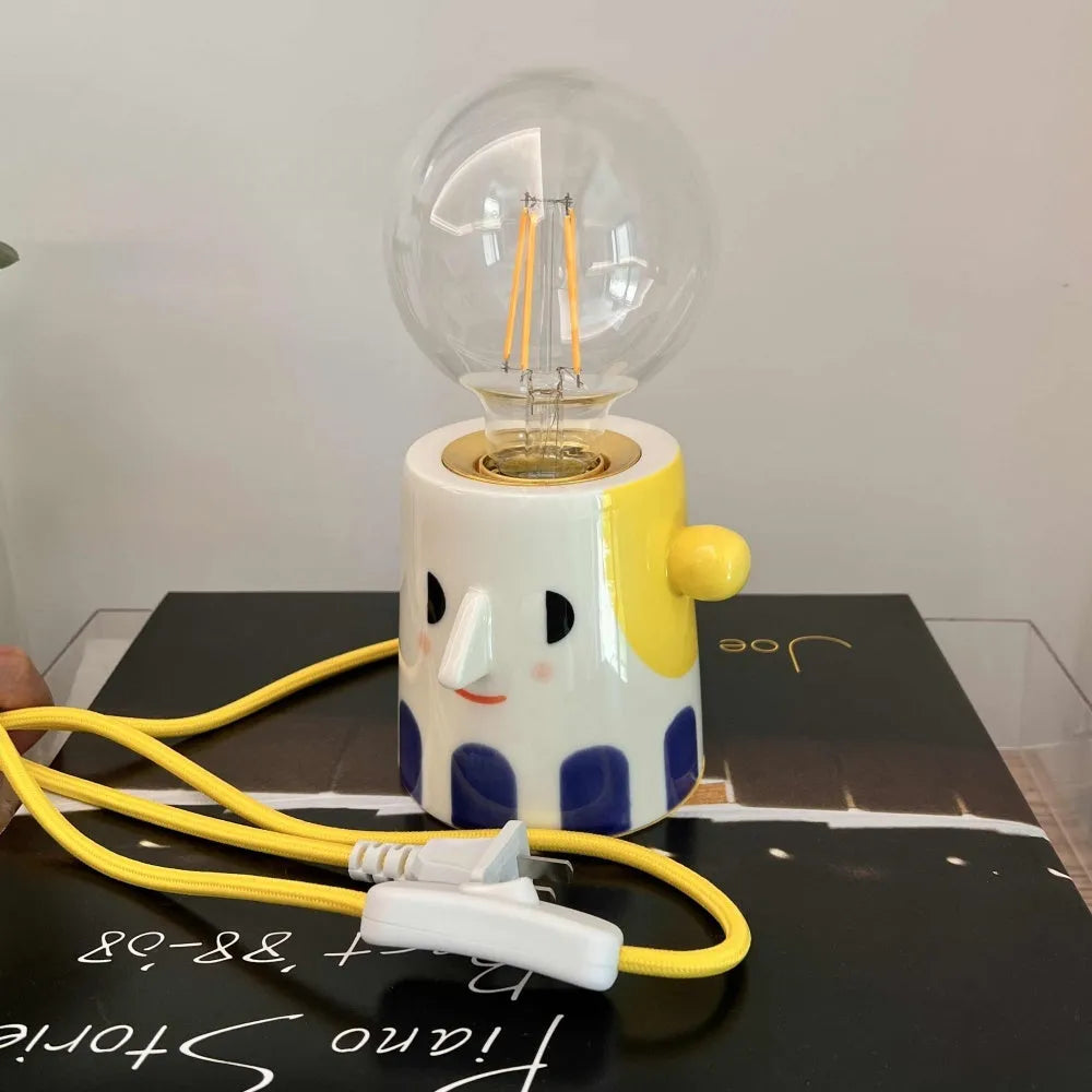 Handmade ceramic table lamp with a spherical ball headlight design on a bedside table.
