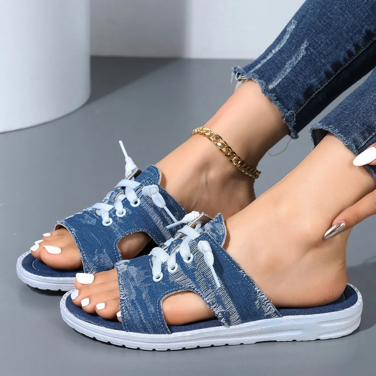 Blue Roman-style women's canvas slippers with rubber soles showing flat design and cloth upper material