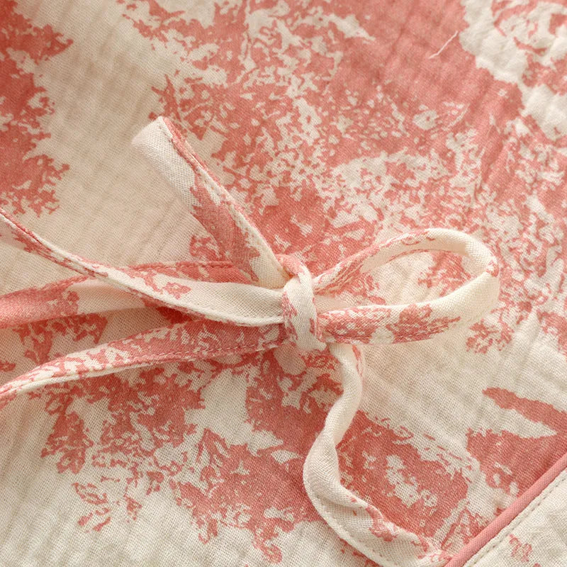 Women's pink cotton gauze long sleeve top and trousers matching loungewear set laid flat.