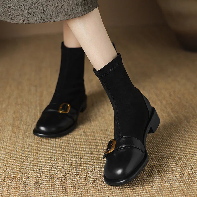 Women's black low heel Martin boots with belt buckle stitching and front lace-up closure on a round toe.