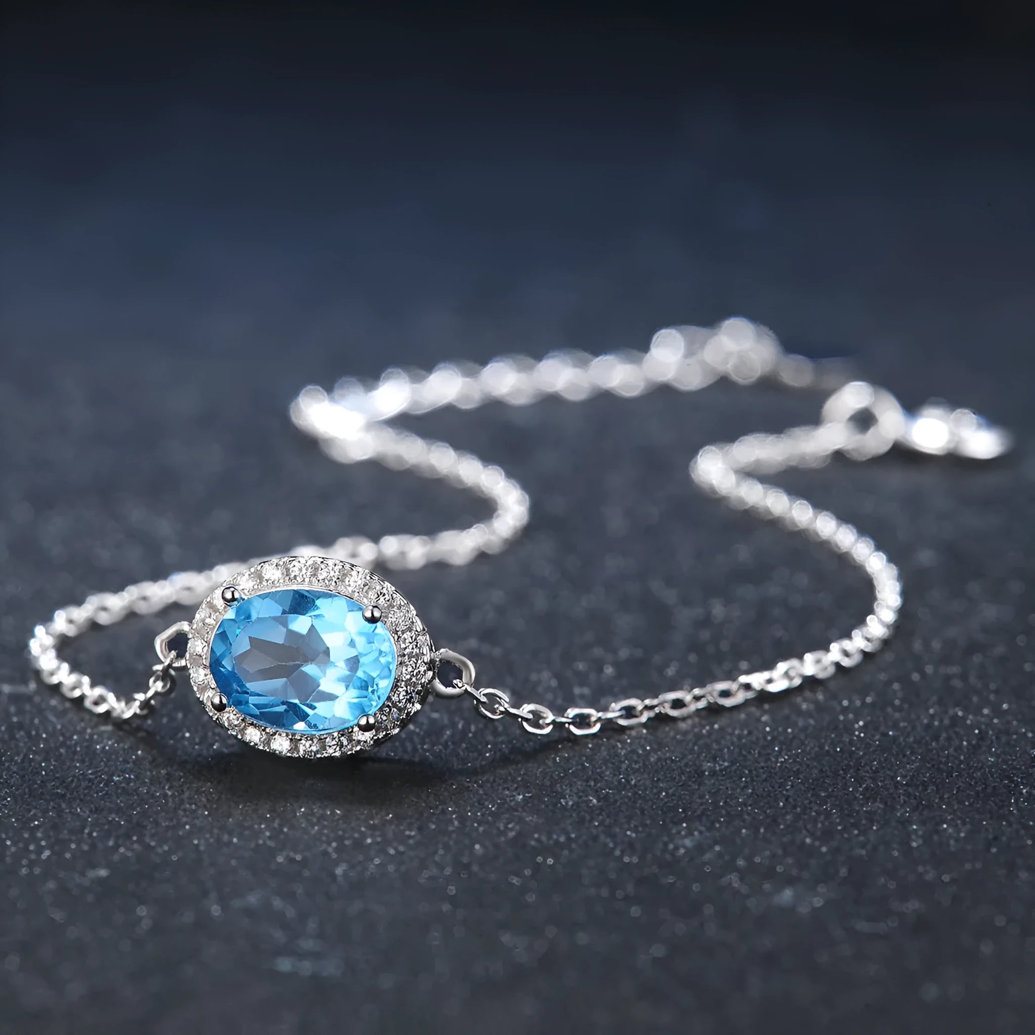 Four-piece 925 sterling silver jewellery set with blue topaz stones: geometric necklace, earrings, ring, and pendant.