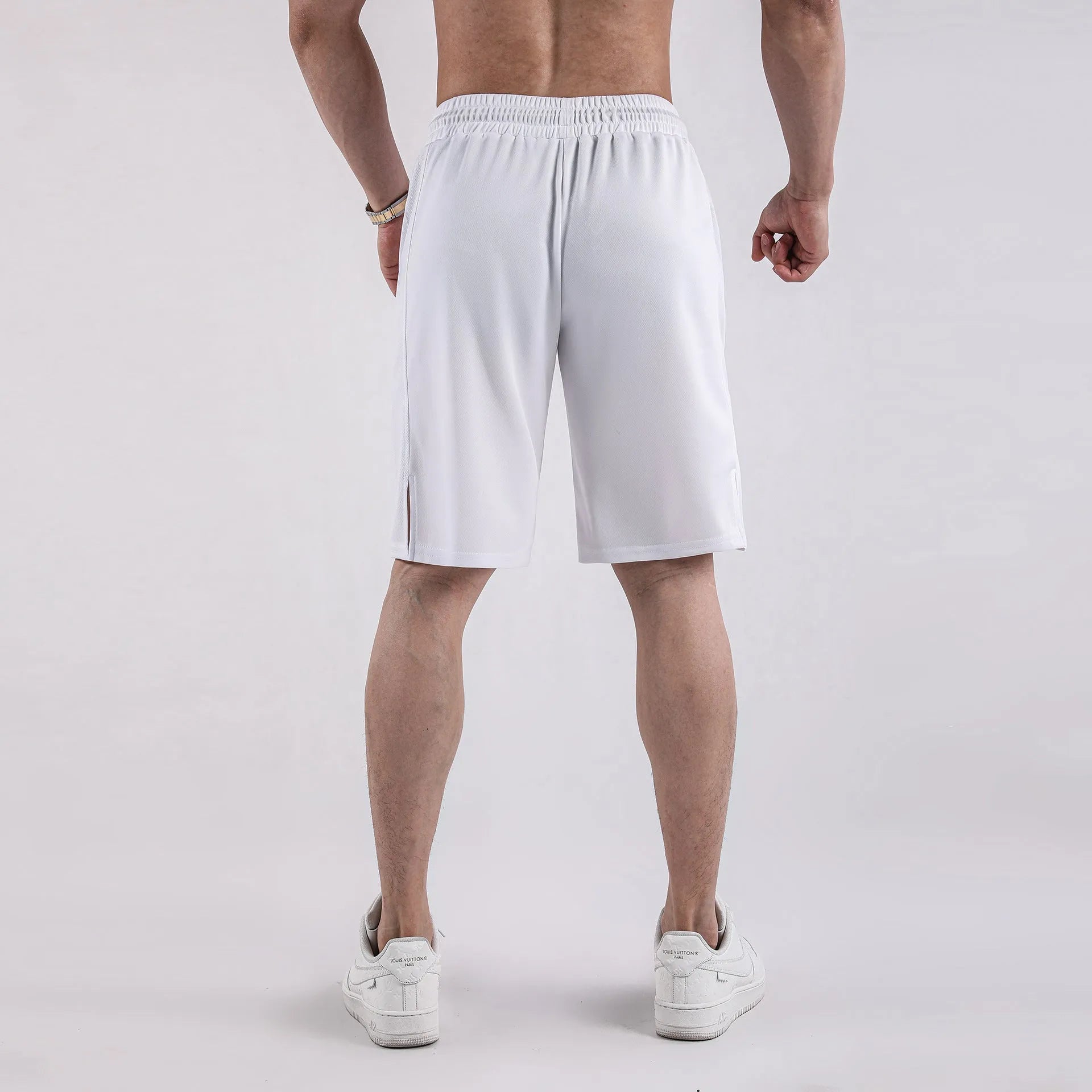Man wearing black loose-fit quick-dry mesh shorts for summer sports.