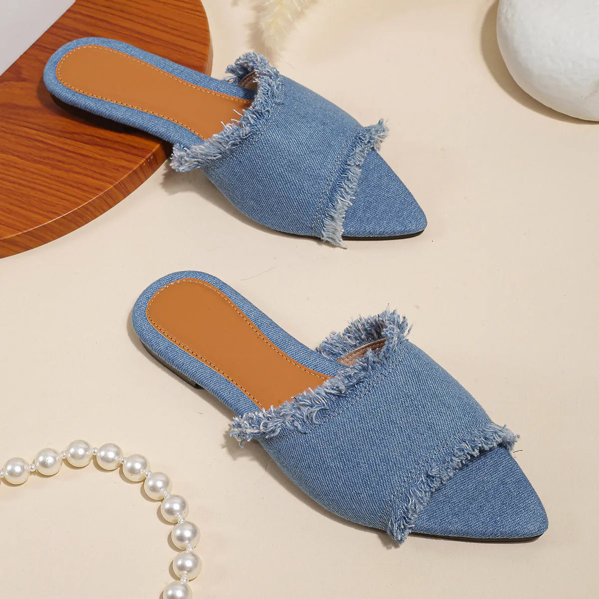 Women's casual denim flat slippers with leather lining and tassel detail.