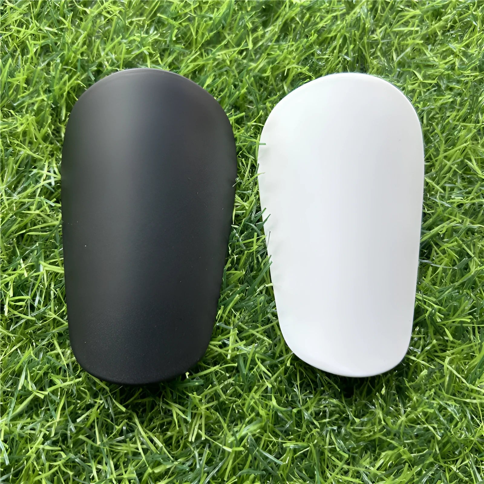 Extra small mini plastic football shin guards in black and white 8x5cm sizes