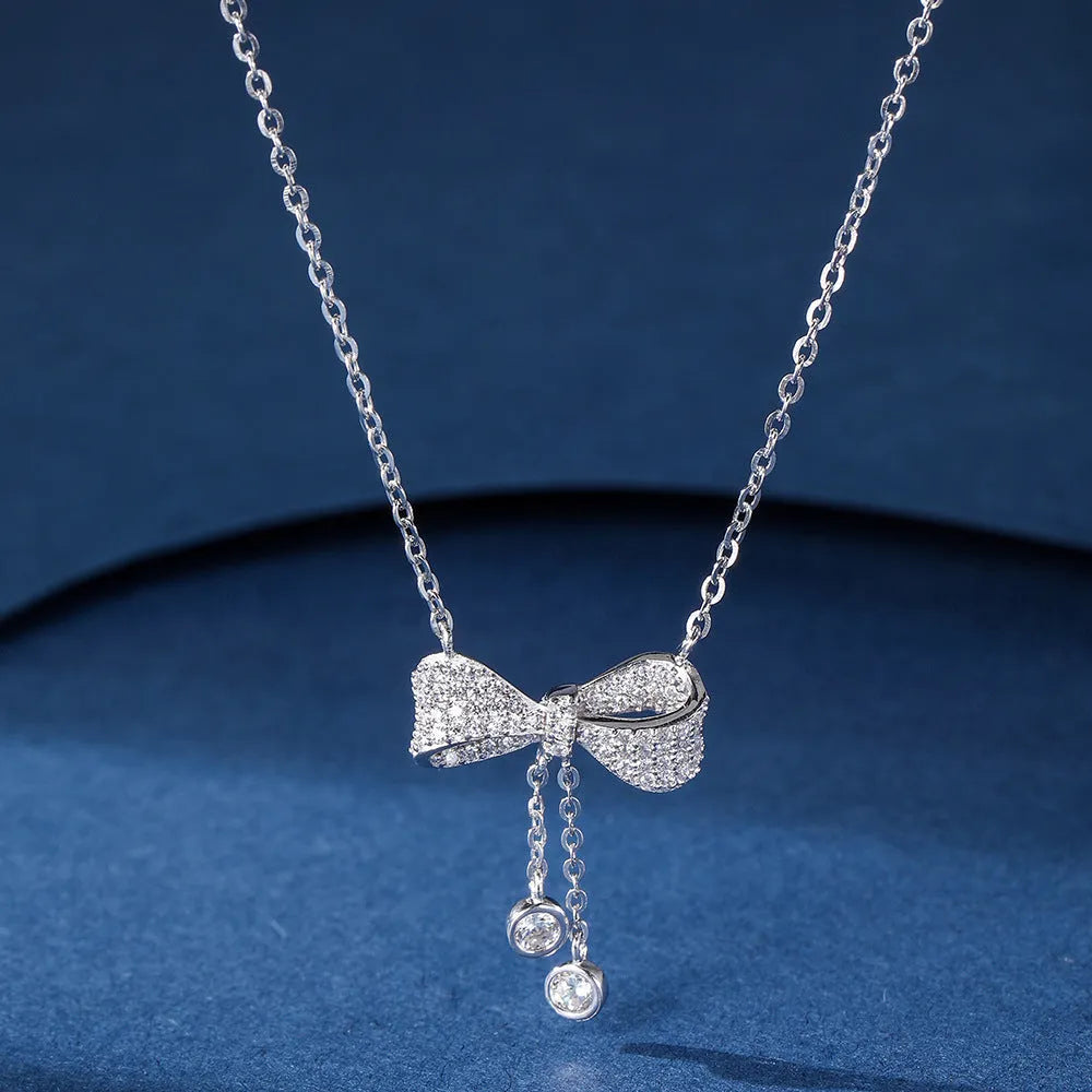 S925 sterling silver bow pendant necklace with O-ring chain on grey background