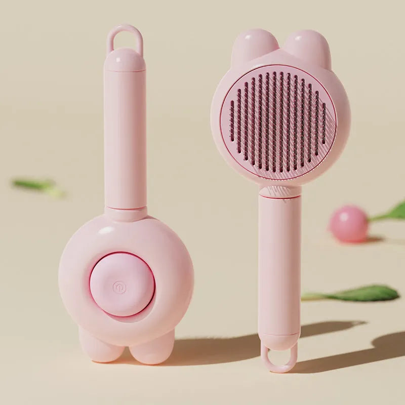 Self-cleaning pet grooming brush with green handle and stainless steel comb, showing the one-click release button.