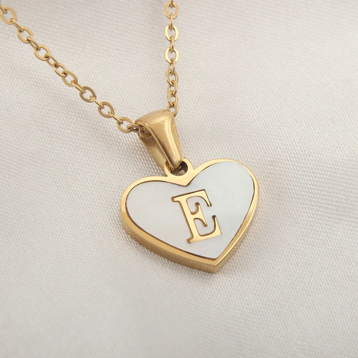 Gold heart necklace with white shell detail and personalised initial letter on adjustable chain