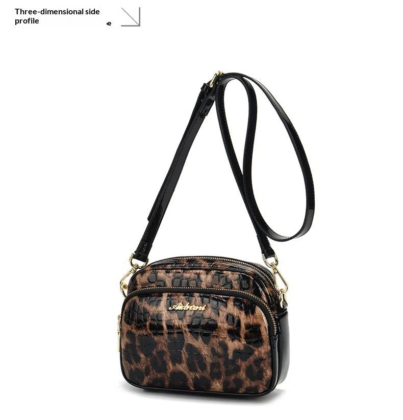 Leopard print crossbody phone bag with PU finish, zip pocket, and 120 cm shoulder strap on neutral background