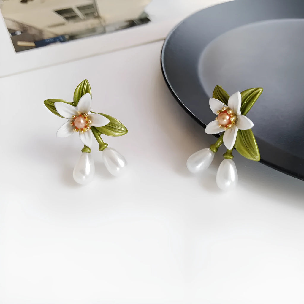 Two pairs of women's floral alloy earrings: one clip-on flower style and one pair of sterling silver needle flower studs.