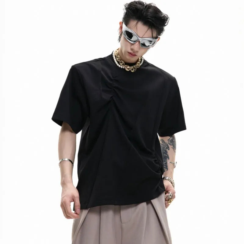 Man modelling a loose grey cotton T-shirt with a round neck and asymmetric stitching detail on the front.