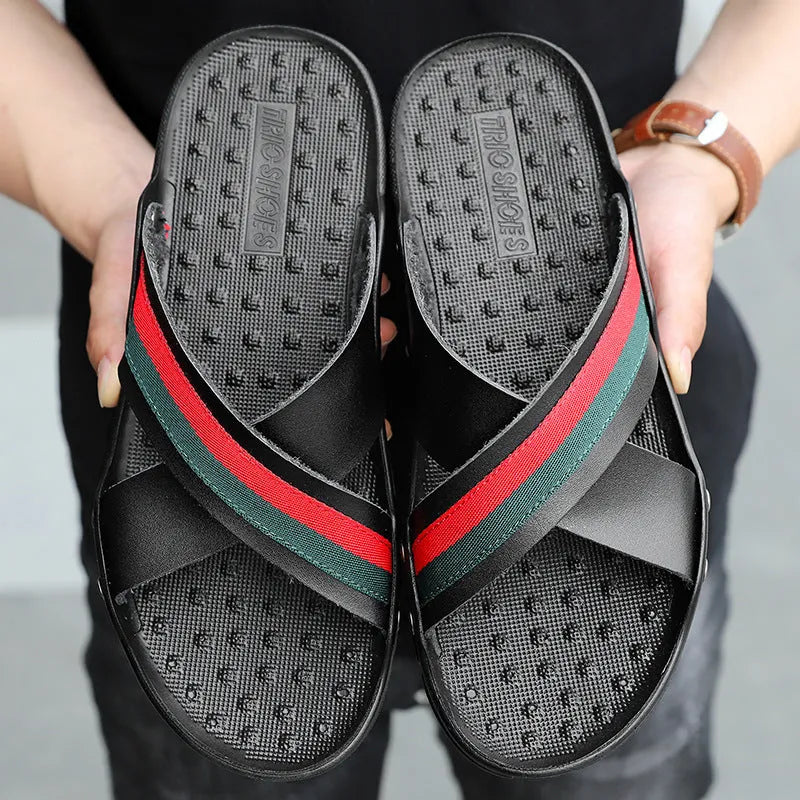Men's black cowhide leather beach sandals with a non-slip PU sole on a wooden deck.