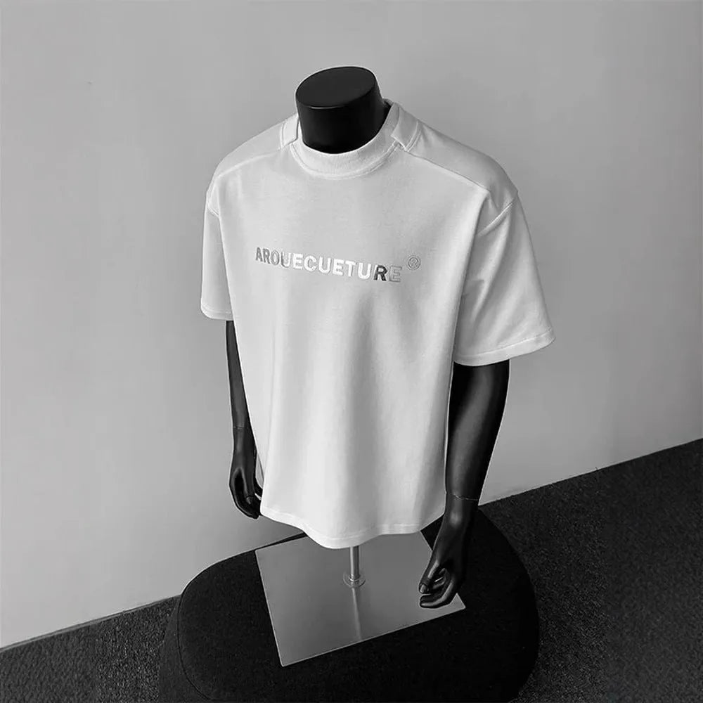 Men's loose fit cotton t-shirt with short sleeves and a printed letter design in light grey.