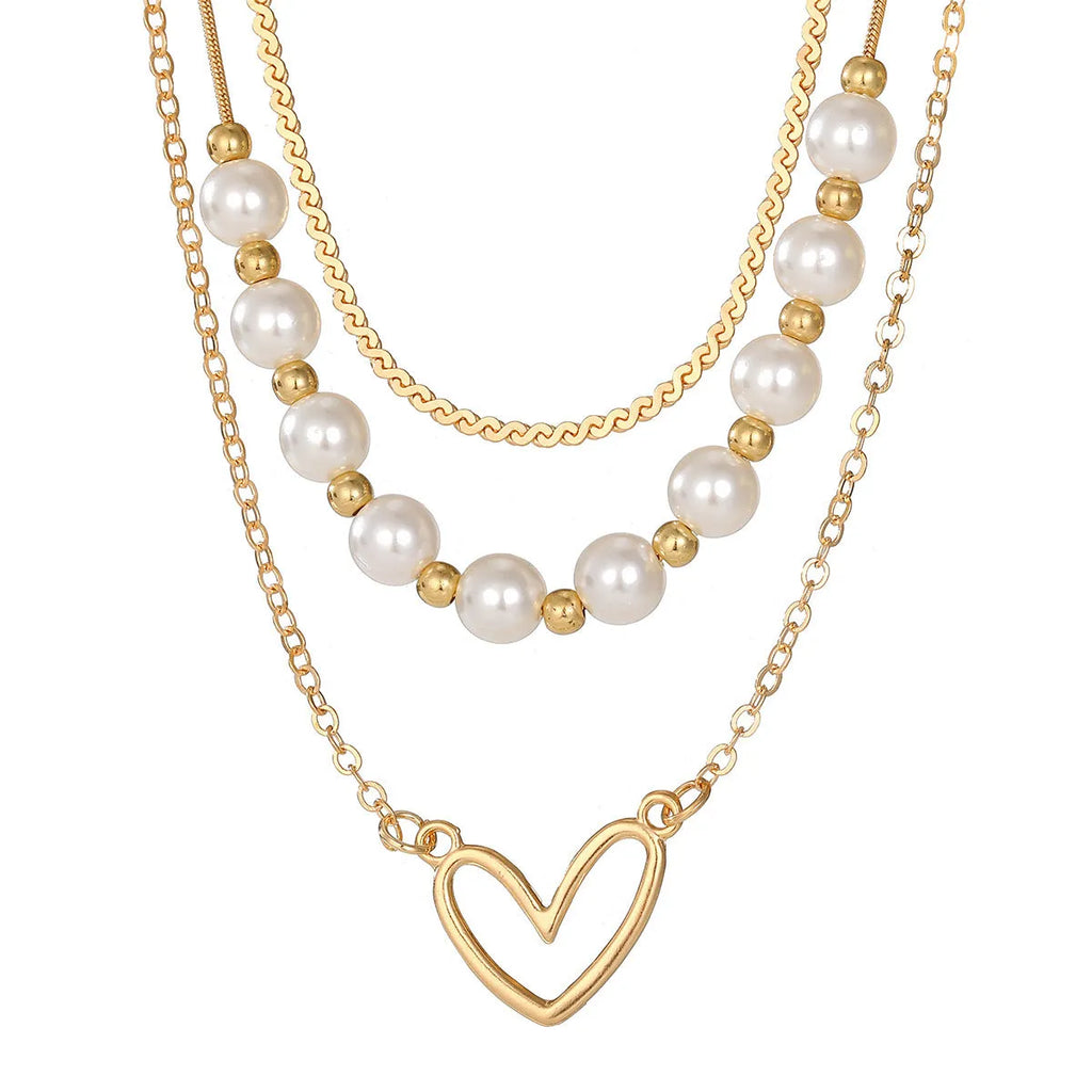 Vintage gold heart pearl necklace with adjustable chain on white background