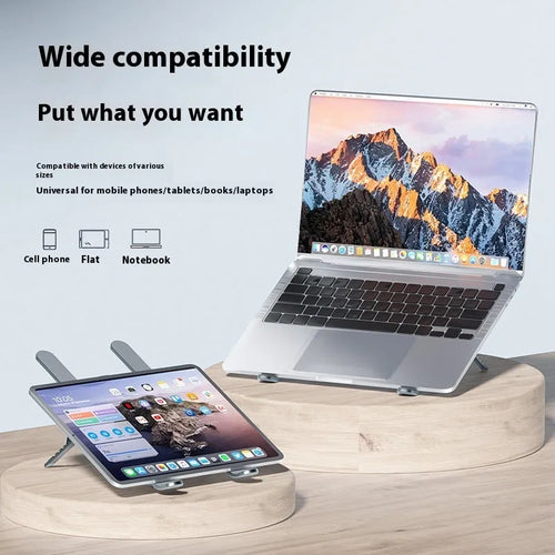 Silver aluminium laptop stand with twin fans raised at an angle on a wooden desk.