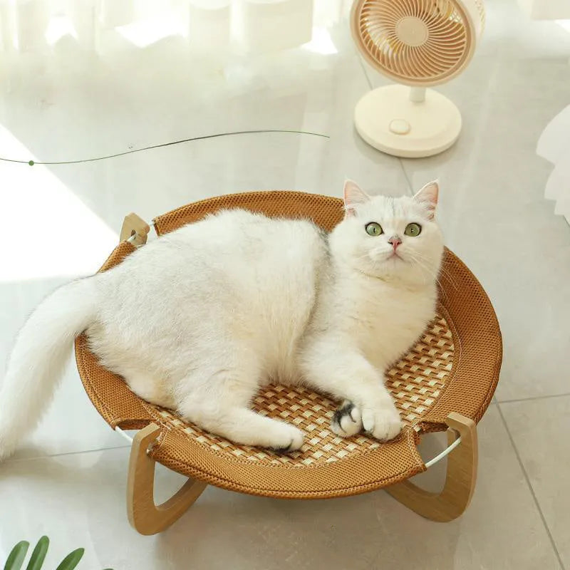 Brown square woven rattan pet hammock bed for cats and small dogs on a wooden floor.